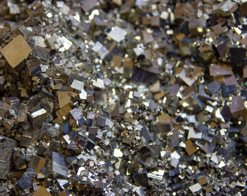 Dense cluster of shiny brassy pyrite crystals showing metallic texture