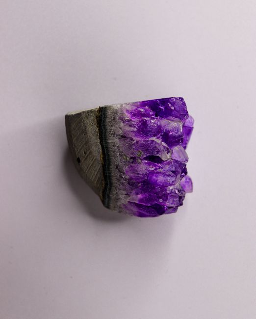 Raw amethyst crystal cluster on grey matrix